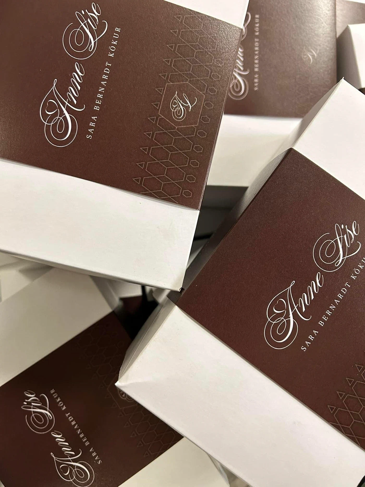 Anne Lise chocolate boxes with delicate calligraphy and gold knitting-inspired patterns