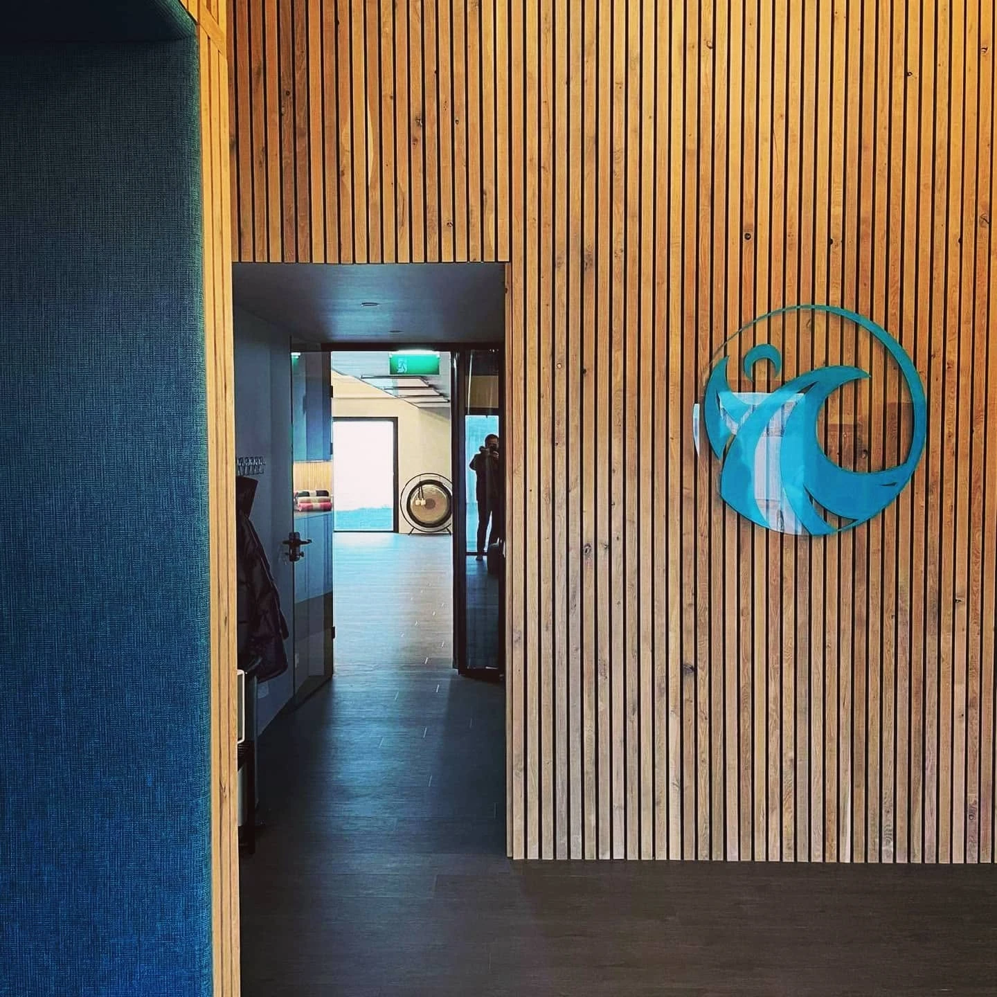 The identity installed on a timber wall at the centre.